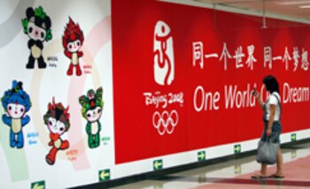 A pedestrian uses her mobile phone to take a photograph of the Beijing 2008 Olympic games billboard, displayed in central Beijing, 06 August 2007. The Olympic spotlight is making the communist rulers of China more vulnerable to global pressure than ever before, rights groups and activists say as they ready for 12 months of intense campaigning. AFP PHOTO/TEH ENG KOON (Photo credit should read TEH ENG KOON/AFP/Getty Images)