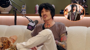 Tommy Lee, con cabello oscuro y tatuajes, sentado en un sofá claro frente a un micrófono. Un perro pequeño está a su lado. Arriba a la derecha, una imagen de Nikki Sixx