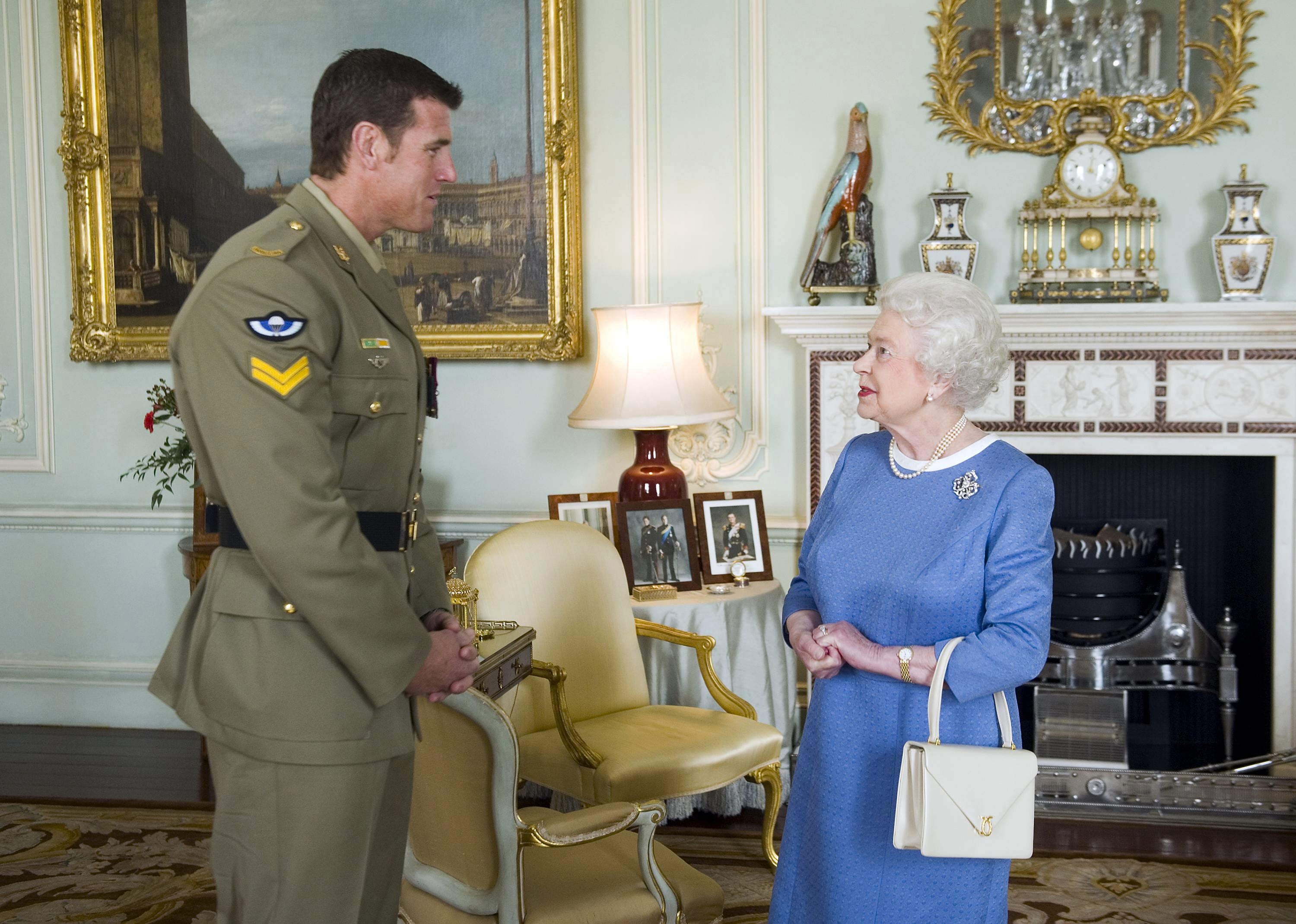 La reina Isabel II de Gran Bretaña saluda al cabo Ben Roberts-Smith, de Australia, quien recientemente recibió la Cruz Victoria, durante una audiencia en el Palacio de Buckingham en Londres, el 15 de noviembre de 2011. (Anthony Devlin/Pool vía AP, Archivo)