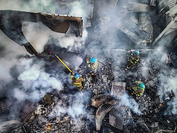 Bomberos trabajan entre los escombros