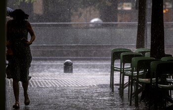 Una mujer corre para refugiarse durante un chaparrón en San Sebastián, a 2 de junio de 2026. (EFE/Javier Etxezarreta)