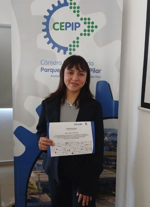 María Luján con su certificado de capacitación en la Fundación EMPUJAR