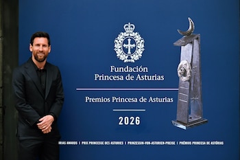 Lionel Messi con traje oscuro junto a un panel azul que contiene el logotipo de la Fundación Princesa de Asturias y la imagen de una escultura