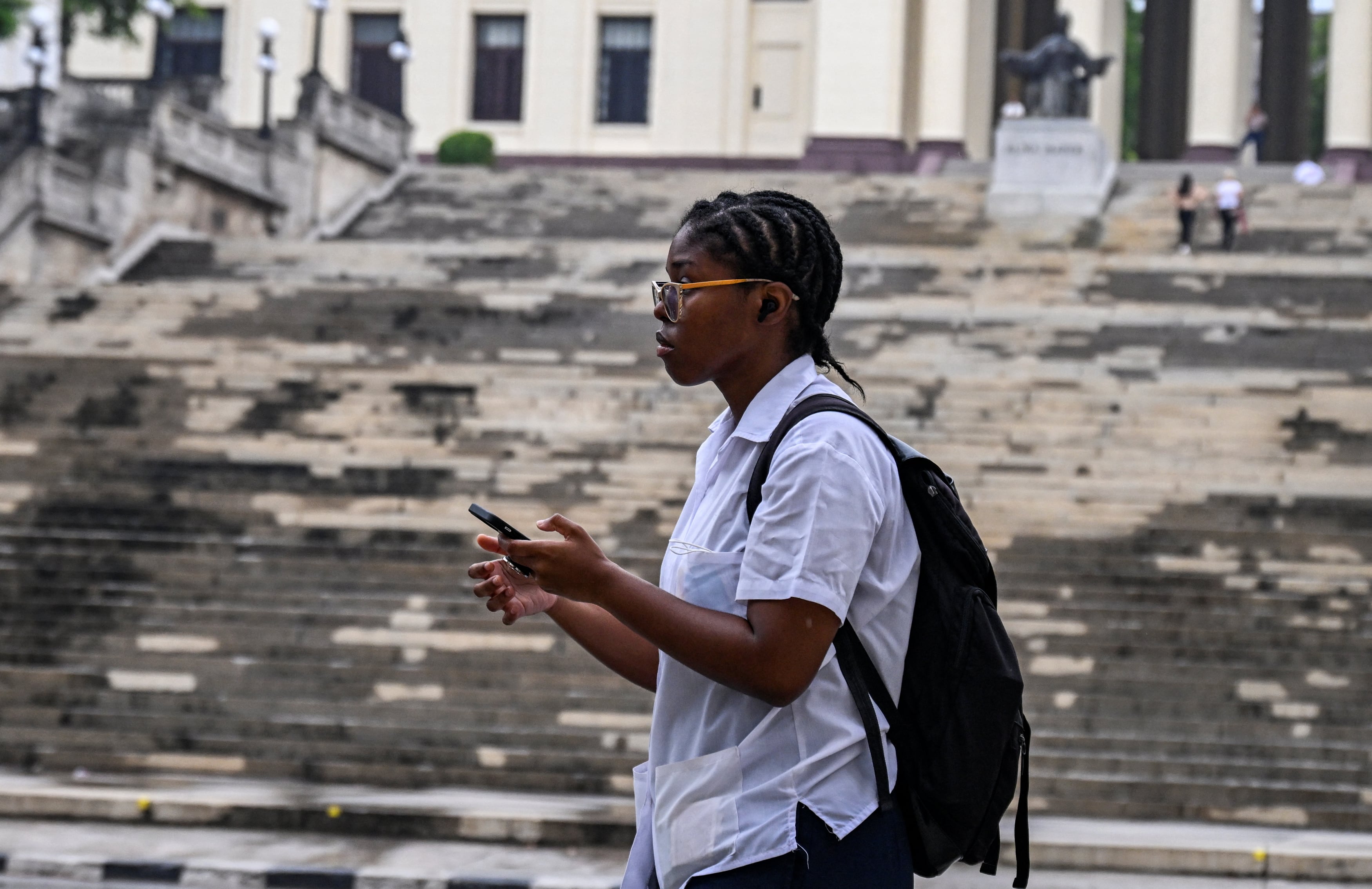 Un estudiante usa su teléfono móvil en La Habana el 4 de junio de 2025. Las nuevas tarifas de internet móvil en Cuba, que entraron en vigor el 30 de mayo y dolarizaron parcialmente el servicio, han desatado una ola de descontento entre los usuarios (Foto de YAMIL LAGE / AFP)