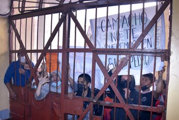Presos llevan un cartel que dice "Camacho, no te queremos en San Pedro", durante una protesta contra el posible traslado del gobernador de Santa Cruz Luis Fernando Camacho a ese centro de detención en La Paz, Bolivia, el jueves 29 de diciembre de 2022. La policía detuvo el miércoles a Camacho, principal líder de la oposición, cerca de su casa en Santa Cruz. La Fiscalía General dijo que Camacho fue detenido como parte de un caso en el que él es señalado de liderar lo que el gobierno califica de golpe de Estado en 2019. (AP Foto/José Lavayen)