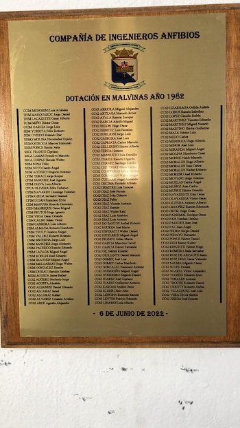 Placa conmemorativa de madera con grabado en metal dorado, mostrando el escudo de la Compañía de Ingenieros Anfibios y una lista de nombres