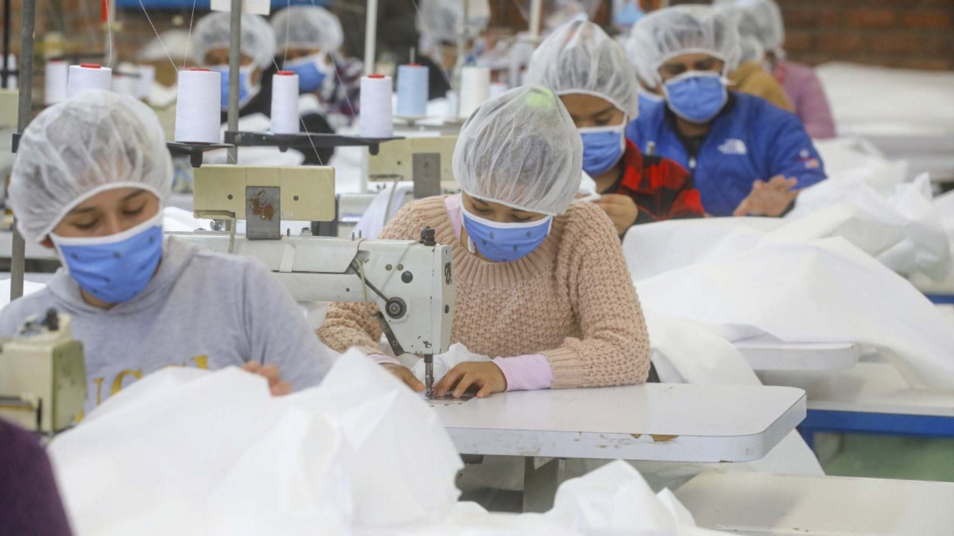 Mujeres emprendedoras trabajan en un taller de costura.