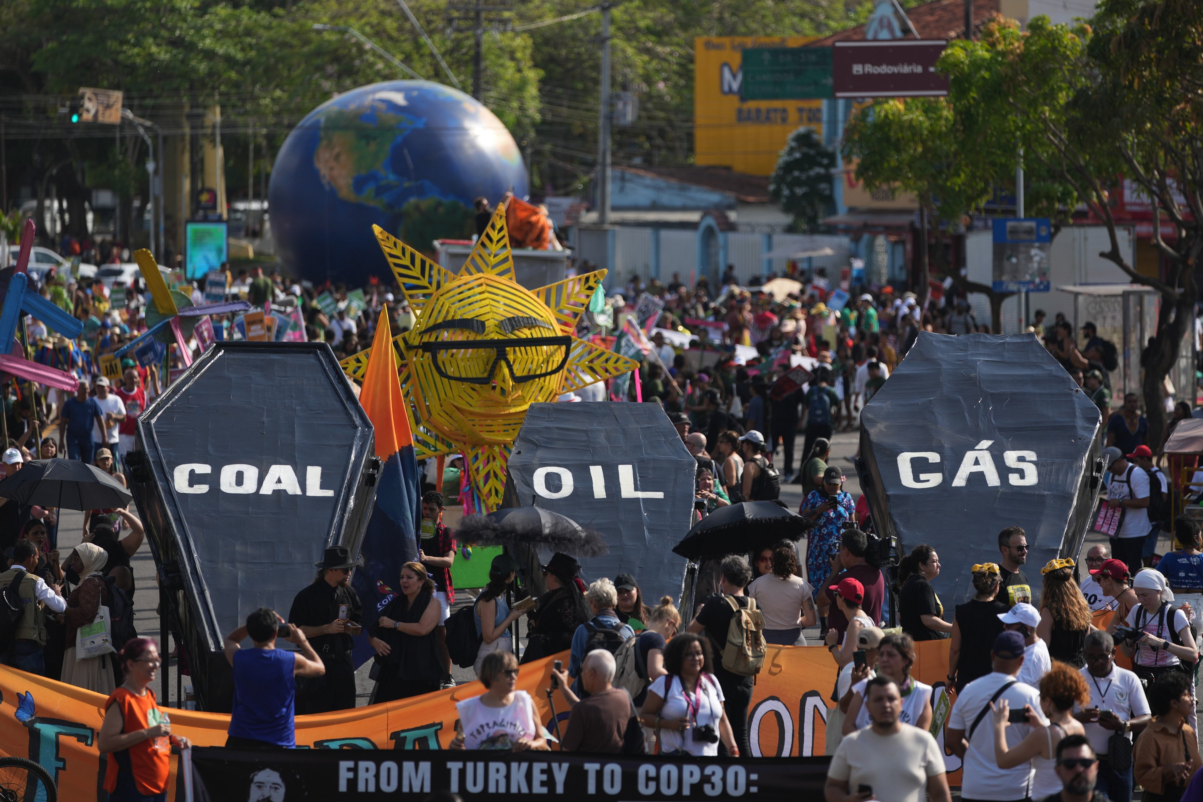 Activistas climáticos protestan con ataúdes con leyendas que dicen carbón, petróleo y gas en Belém, Brasil (AP Foto/Andre Penner)