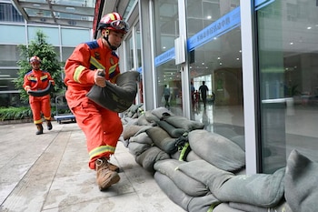 Bomberos acomodan sacos de arena en Wenzhou, China (CN-STR / AFP)