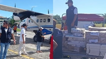 Varias personas cargan cajas de material electoral en y desde una avioneta y un camión en una pista de aterrizaje al aire libre, con árboles al fondo