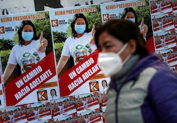 Una mujer peruana residente en Argentina pasa junto al cartel electoral de la derechista Keiko Fujimori frente a una escuela pública, en Buenos Aires (REUTERS/Agustin Marcarian)