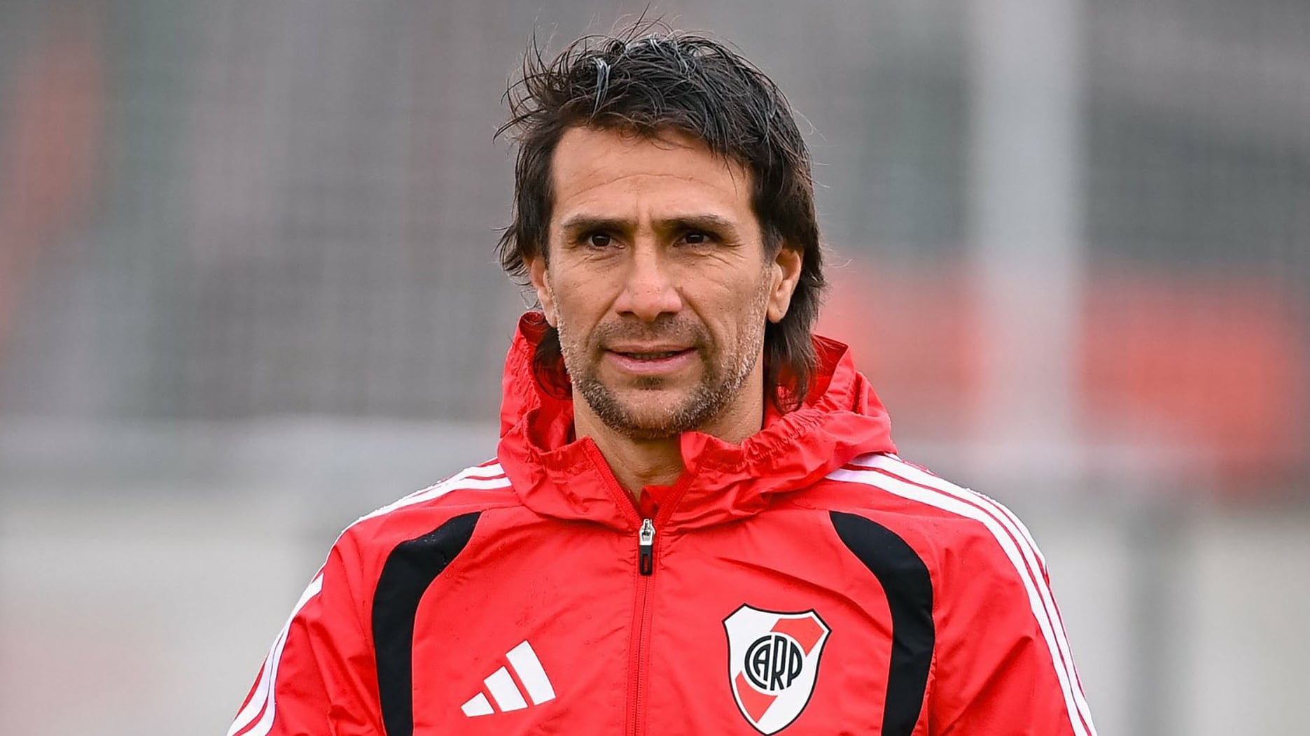 Leonardo Ponzio camina por el campo deportivo luciendo el abrigo oficial de River Plate. (@RiverPlate)