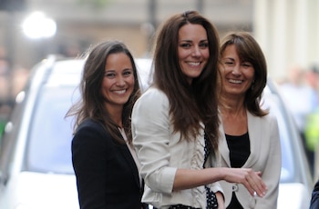 Kate Middleton (M) saluda a la multitud frente al Hotel Goring en Londres, Gran Bretaña, el 28 de abril de 2011, junto a su hermana Pippa (L) y su madre Carole. (FRANK MAY | uso mundial/dpa/Alamy Live News)
