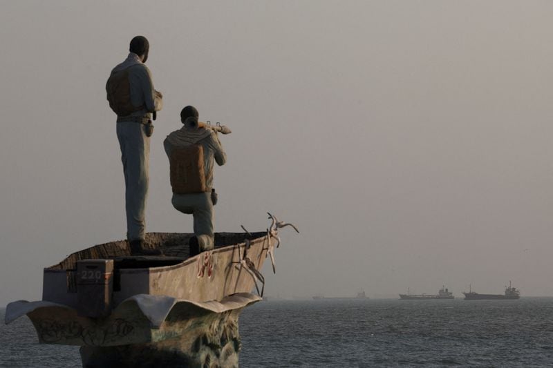 Una estatua de militares iraníes se alza en el estrecho de Ormuz, mientras se divisan embarcaciones cerca de la playa de Bandar Abbas, Irán, el 26 de agosto de 2026. Majid Asgaripour/WANA (Agencia de Noticias de Asia Occidental) vía REUTERS