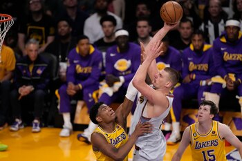 El pívot de los Nuggets de Denver Nikola Jokic lanza el balón sobre Rui Hachimura de los Lakers de Los Ángeles en el juego 4 de las finales de la Conferencia Oeste el lunes 22 de mayo del 2023. (AP Foto/Mark J. Terrill)