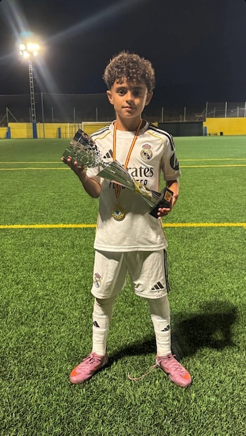 David Sánchez Miralles posa en el campo con el trofeo y la medalla de campeón, tras una conquista con el Alevín A del Real Madrid en 2025 (Foto cortesía @mfutbolspain).