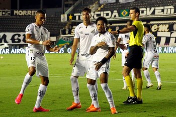 El jugador Marinho (d) de Santos celebra hoy con sus compañeros Kaio Jorge (c) y Madson tras anotar contra Gremio, durante un partido por los cuartos de final de la Copa Libertadores 2020 en el estadio Vila Belmiro, en Santos (Brasil). EFE/ Alexandre Schneider