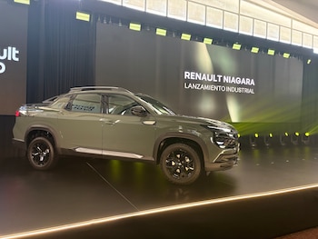 Una pickup verde olivo permanece sobre un escenario frente a una pantalla con la inscripción Renault Niagara lanzamiento industrial