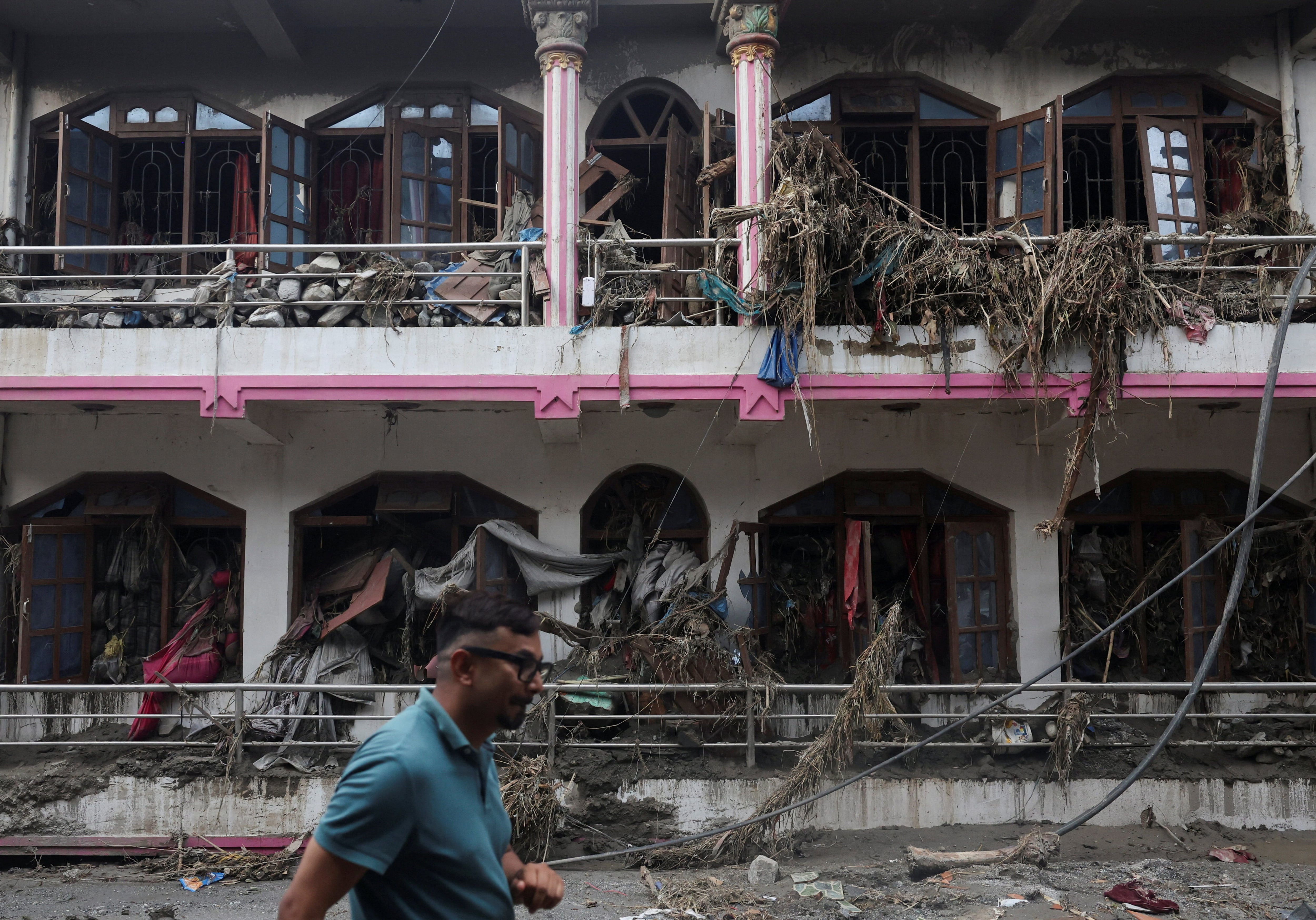 Un hombre pasa junto a una casa dañada tras inundaciones repentinas y un deslizamiento de tierra en Devighat, distrito de Nuwakot, Nepal (REUTERS/Francis Mascarenhas)