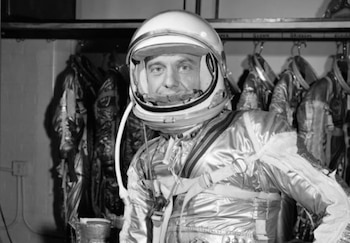 Imagen en blanco y negro de Alan Shepard, primer estadounidense en el espacio, vestido con su traje espacial y casco, mirando al frente