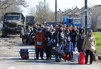 Evacuees wait before boarding a