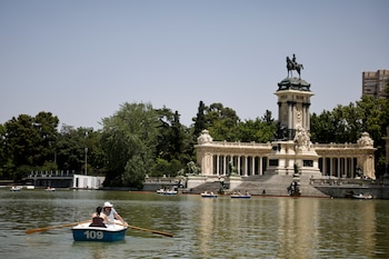 Varias personas montan en las barcas del estanque del Parque del Retiro, este martes. (Marcos Villaoslada/EFE)