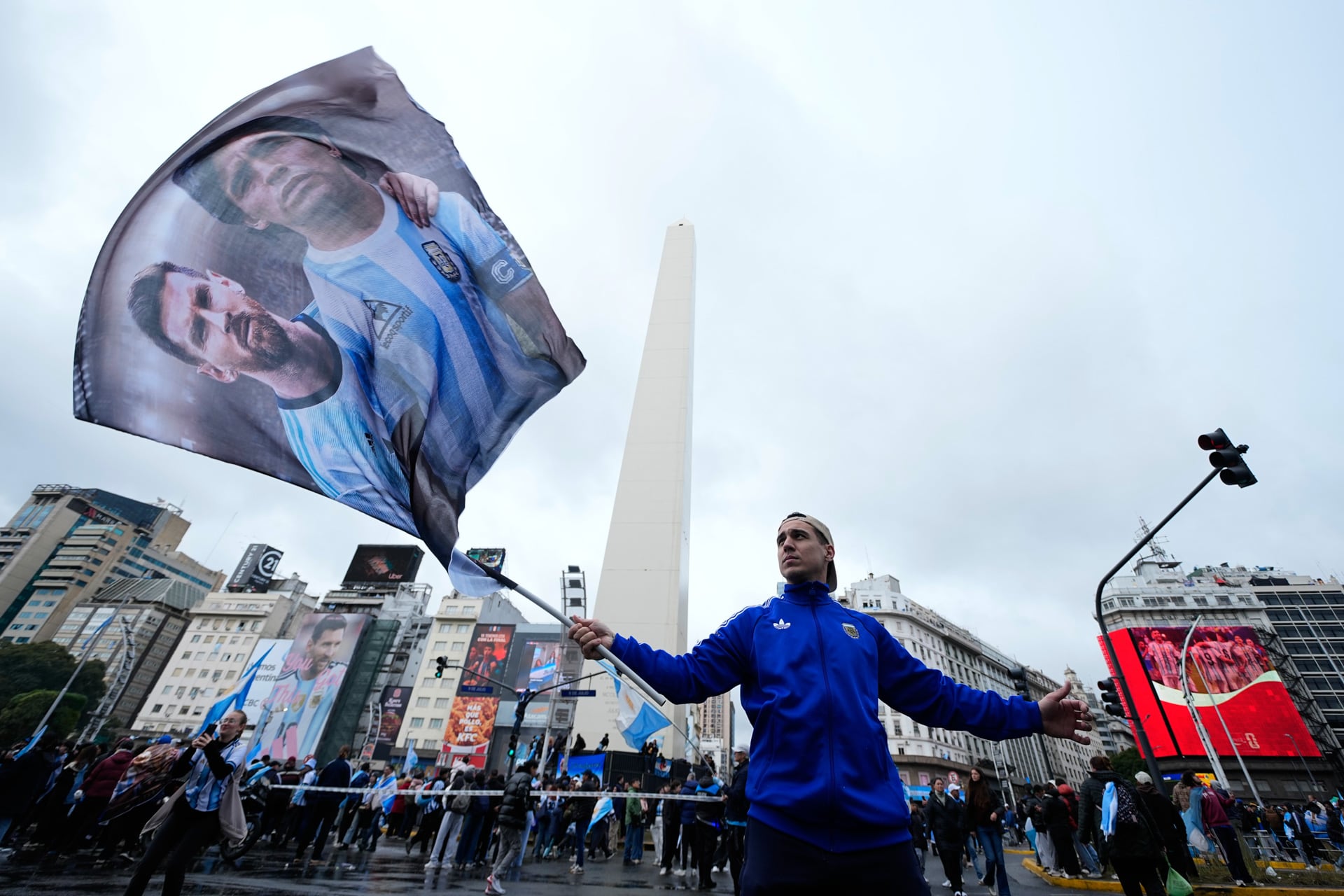 Un hincha con una bandera de Messi y Maradona