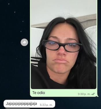 Primer plano de una mujer de cabello oscuro y gafas negras, haciendo un puchero, dentro de una captura de pantalla de un chat de WhatsApp con mensajes