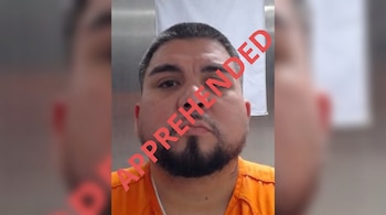 Retrato de un hombre de cabello oscuro y barba con prenda naranja y el texto APPREHENDED en letras rojas atravesando la imagen.