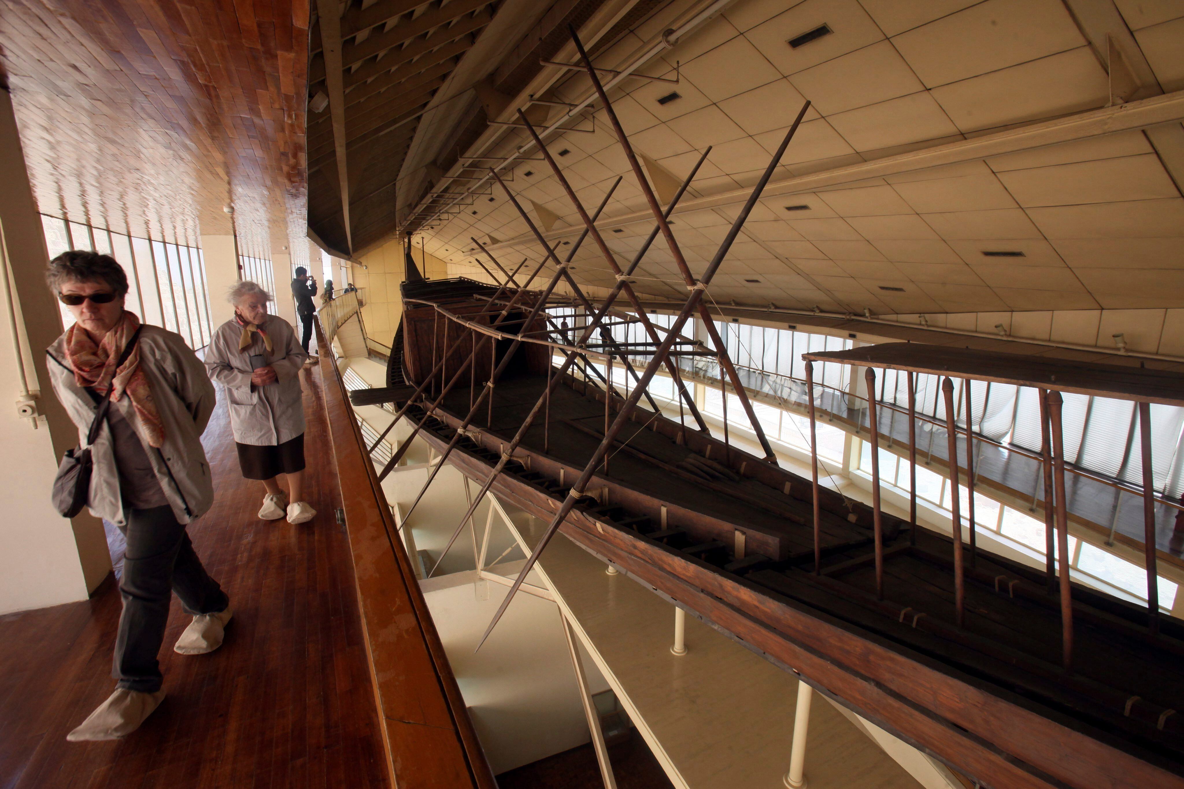 Visitantes observan la barca solar de Keops expuesto en el museo ante la gran pirámide en Guiza, Egipto