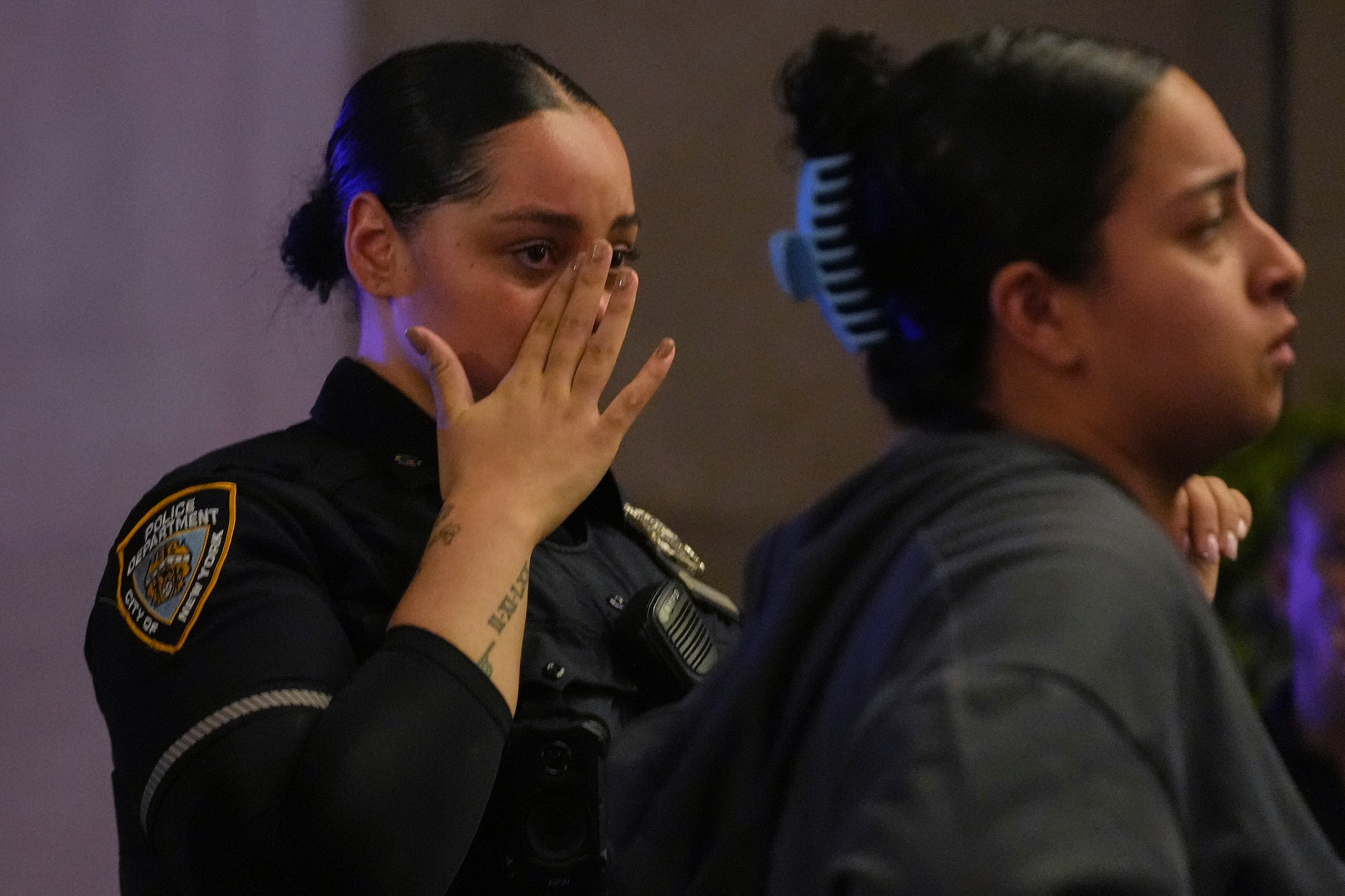 Un policía llora tras enterarse de la muerte de su compañero (AP Photo/Angelina Katsanis)