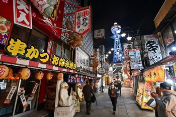 FOTO DE ARCHIVO: Varias personas con mascarillas caminan por una calle casi desierta del distrito comercial Shinsekai en la ciudad de Osaka, Japón, el 12 de enero de 2021. Agencia Kyodo/vía REUTERS