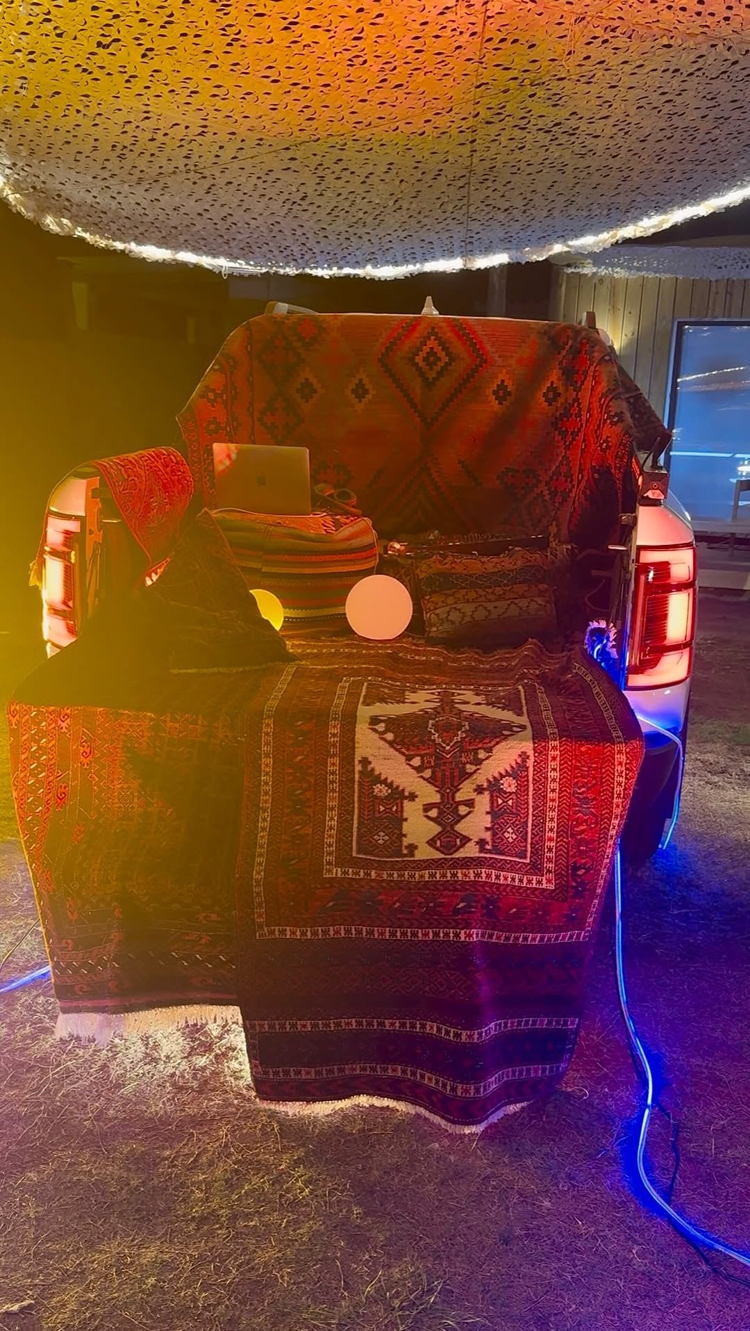 Con una ingeniosa decoración, la caja de una camioneta se transforma en un elegante y confortable rincón lounge adornado con textiles, una cabina de DJ y luces cálidas (IG lacalurivero)