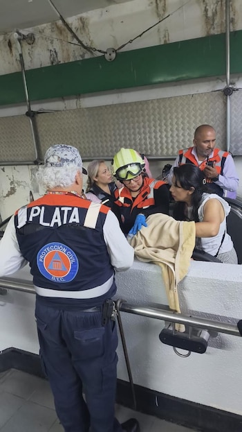Varios rescatistas, incluyendo personal de Protección Civil, rodean una escalera eléctrica en el Metro Salto del Agua, atendiendo a un animal cubierto
