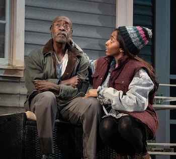 Don Cheadle, con gafas y barba, sentado con los brazos cruzados, mientras Ayo Edebiri, con gorro y chaleco, le mira atenta con una mano en su hombro