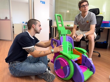 Guillermo y Carlos montan una silla diseñada para un niño pequeño.