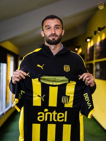 Germán Pezzella posa con la camiseta de Peñarol de Uruguay (@OficialCAP)