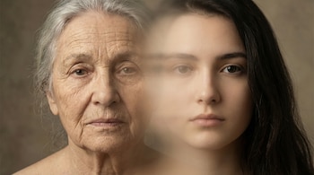 Primer plano de un rostro dividido: el lado izquierdo muestra piel arrugada y cabello canoso, el derecho tiene piel tersa y cabello oscuro, con una transición difusa.