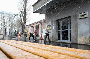 Hombres caminan frente a la redacción de Nóvaya Gazeta en Moscú este jueves durante el operativo policial. El Ministerio del Interior invocó un caso de uso ilegal de datos personales para justificar el registro. (Igor Ivanko/AFP)