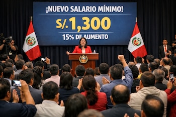 Mujer en podio, dos banderas de Perú, pantalla con "Nuevo salario mínimo S/. 1.300, 15% de aumento". Numerosa audiencia aplaude y graba con móviles.