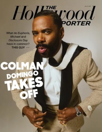 Primer plano de Colman Domingo en la portada de una revista, vistiendo un traje beige con solapas negras y una camisa blanca, desabrochándose el saco