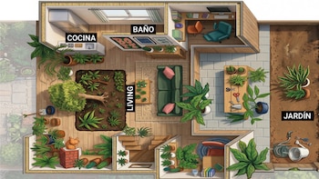 Sala bien iluminada con muchas plantas de interior en macetas y colgantes. Un mueble de madera y una alfombra de patrones geométricos son visibles