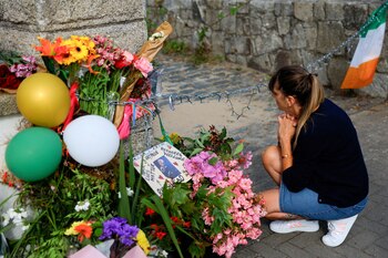 Una mujer se arrodilla cerca de los tributos frente a la antigua casa de la difunta cantante irlandesa Sinead O'Connor el día de su cortejo fúnebre, en Bray, Irlanda, el 8 de agosto de 2023. REUTERS/Clodagh Kilcoyne