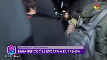 Maia Reficco camina rodeada de personas en la calle, con un cartel televisivo morado en la parte inferior