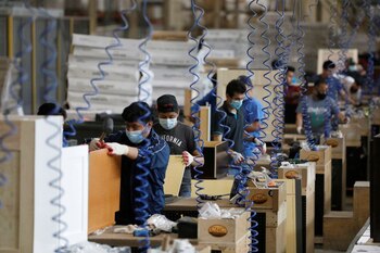 Trabajadores ensamblan gabinetes en CNC