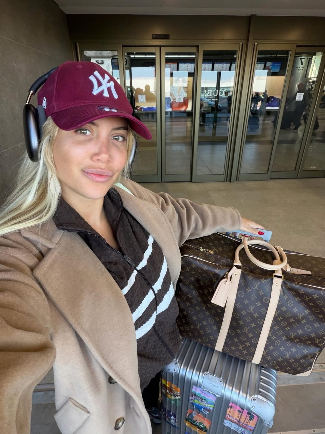 Nara posa sonriente en el aeropuerto, equipada con auriculares y equipaje de lujo, antes de iniciar sus vacaciones con destino a Shanghái, China