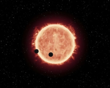 Esta ilustración muestra dos mundos del tamaño de la Tierra pasando frente a su estrella enana roja progenitora en el sistema TRAPPIST-1, a 40 años luz de distancia (ESA/Hubble)