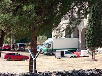 Un camión que lleva material para una boda pasando bajo los arcos del monasterio