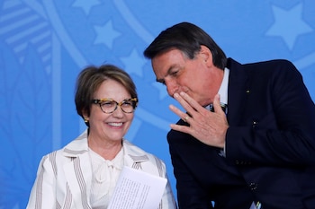 El presidente de Brasil, Jair Bolsonaro, conversa con la ministra de Agricultura, Tereza Cristina Dias, durante la ceremonia de regularización provisional de tierras en el Palacio de Planalto, en Brasilia, Brasil, el 10 de diciembre de 2019. REUTERS/Adriano Machado