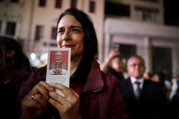 Una mujer sostiene una estampita